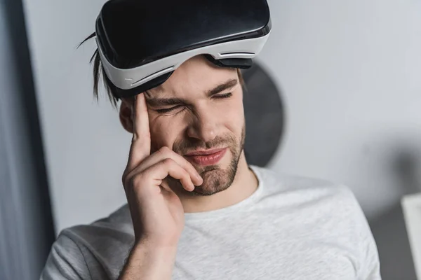 Young man in virtual reality headset having headache — Stock Photo