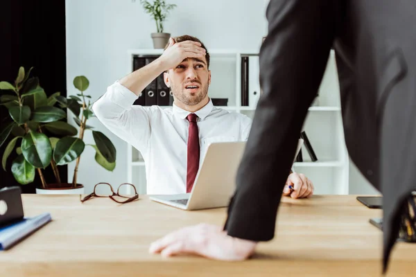 Hombre de negocios asustado con portátil mirando jefe enojado en la oficina — Stock Photo