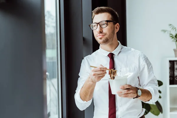 Businessman holding box with noodles for lunch in office — Stock Photo