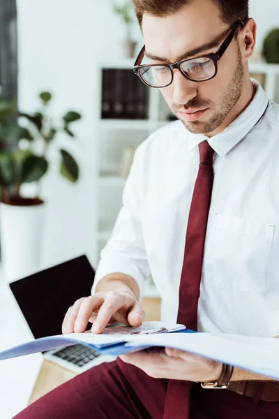 Homem de negócios em óculos lendo documentos da pasta — Fotografia de Stock