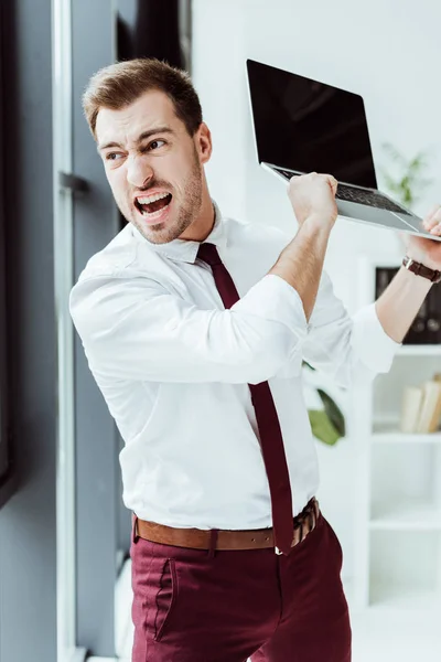 Агресивний бізнесмен кричить і кидає ноутбук в офіс — стокове фото