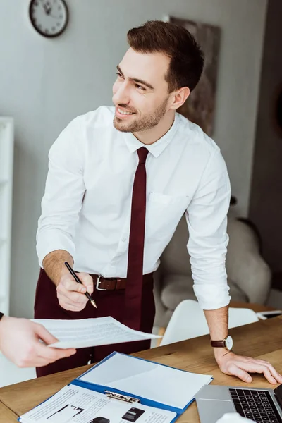 Homme d'affaires travaillant avec des documents et signant un contrat sur le lieu de travail — Photo de stock