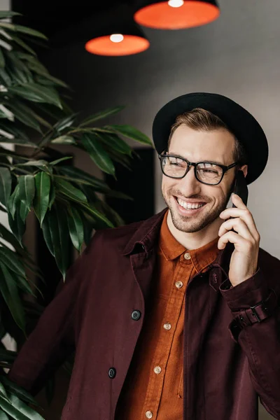 Stylish handsome man laughing and talking on smartphone — Stock Photo
