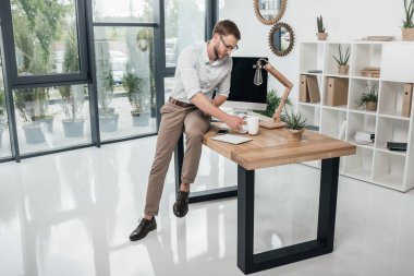 İş adamı masaya yaslanıyor