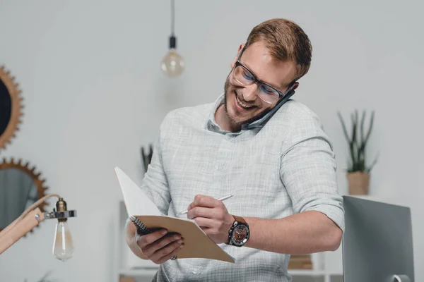 Businessman writing in diary — Stock Photo, Image