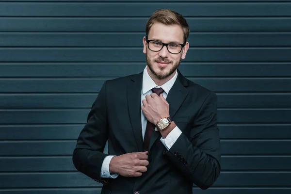 Businessman tying necktie — Stock Photo, Image