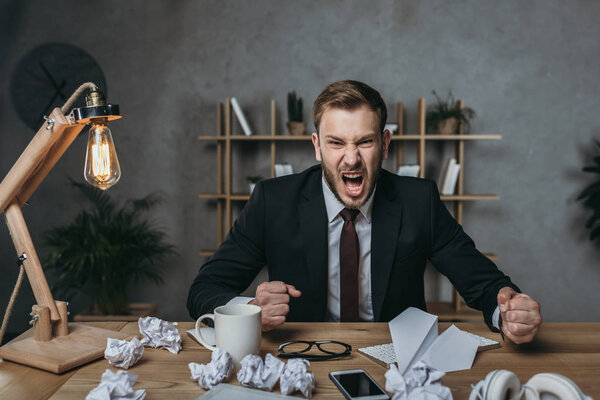 angry businessman yelling while sitting at workplace