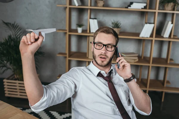 Zakenman aan het praten op smartphone terwijl hij op de werkplek zit — Stockfoto