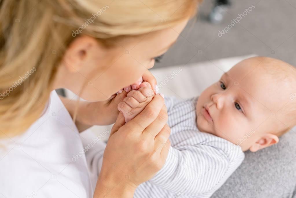 mother holding babys hands