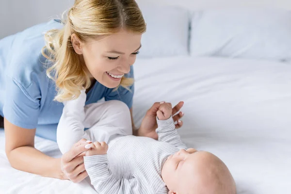 Modern som håller babyns händer — Stockfoto