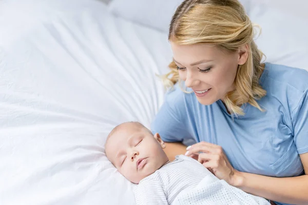Matka při pohledu na spící dítě — Stock fotografie