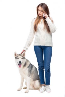 güzel kadın smartphone cep telefonu ile yanında oturan, üzerinde beyaz izole husky köpek süre söz