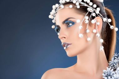 çekici modeliyle saç aksesuarı, Noel çam kozalakları, kış makyaj ve glitter, mavi izole