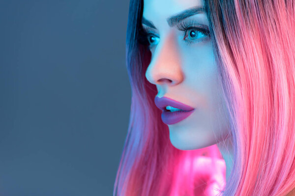 portrait of beautiful woman in pink wig, isolated on blue