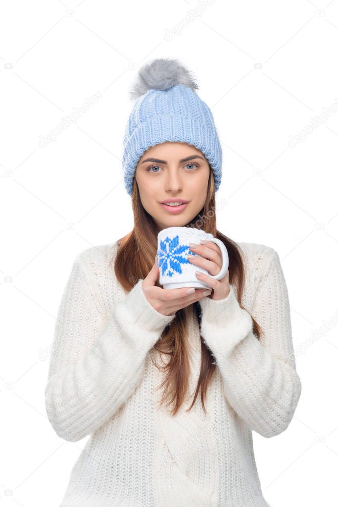 beautiful woman in knitted hat and winter sweater holding cup of hot coffee, isolated on white
