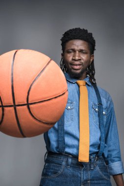 Afrika kökenli Amerikalı adam gri izole basketbol topu ile oynarken