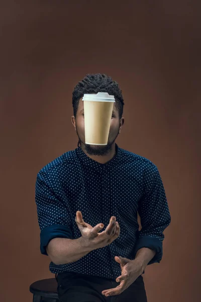 Africano americano hombre la captura de taza de café desechable aislado en marrón — Foto de Stock