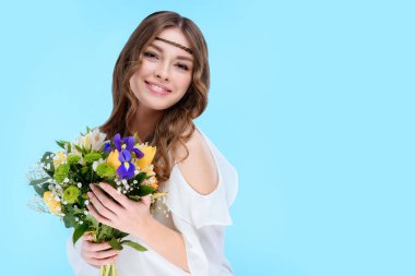 çiçek buketi mavi izole tutan mutlu genç kadın