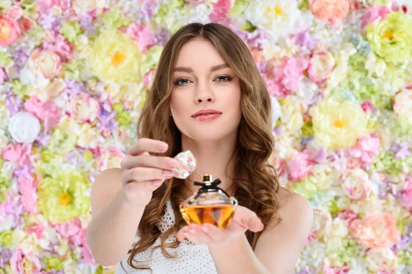 Piękna Młoda Kobieta Otwarcia Butelki Perfum Tle Kwiatów — Zdjęcie stockowe