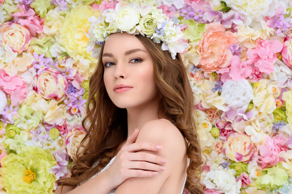 sensual young woman in floral wreath on flral background