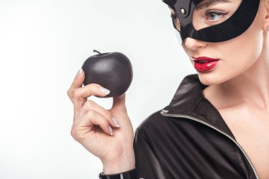 Siyah elma üzerine beyaz izole tutan maskeli baştan çıkarıcı genç kadın