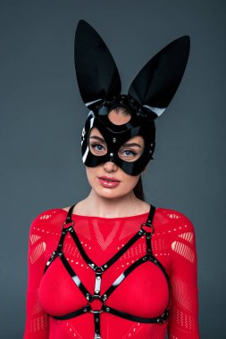Maske ve gri izole swordbelt giyen baştan çıkarıcı genç kadın