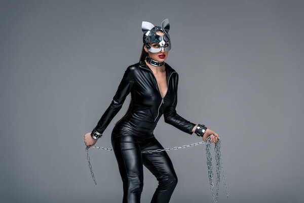 Соблазнительная молодая женщина, держащая цепь изолирована от серых
