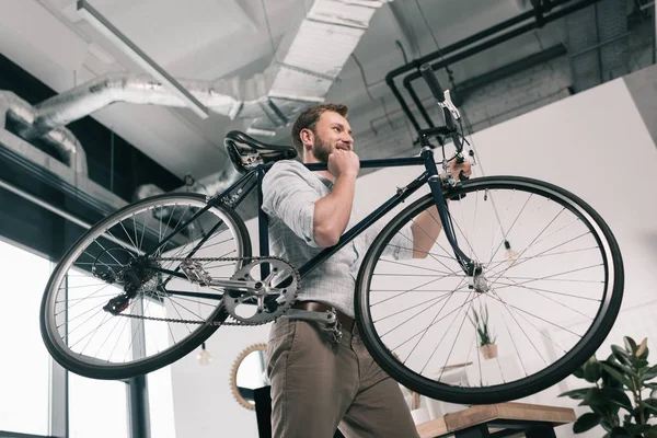 Hombre de negocios llevando bicicleta - foto de stock