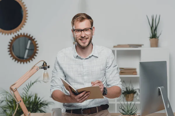 Businessman writing in diary — Stock Photo