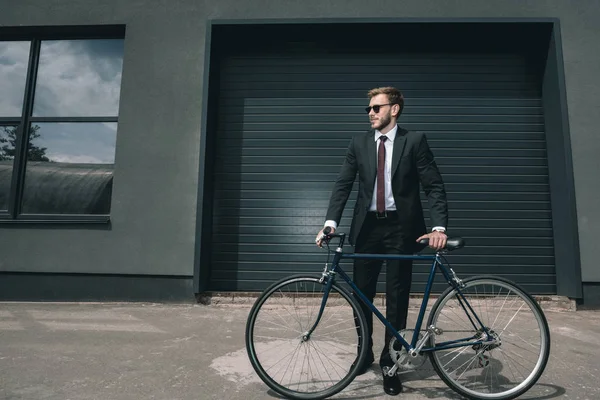 Стильный бизнесмен с велосипедом — стоковое фото