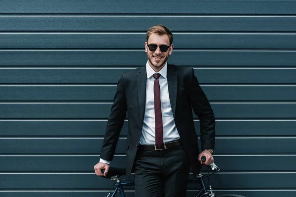 Стильный бизнесмен с велосипедом — стоковое фото