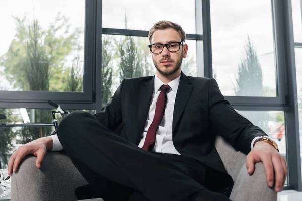 Geschäftsmann im Anzug sitzt im Büro auf Sessel — Stockfoto