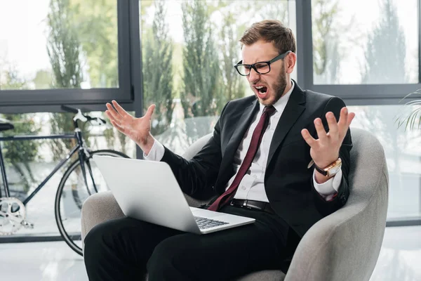 Homme d'affaires en colère crier tout en travaillant sur ordinateur portable — Photo de stock