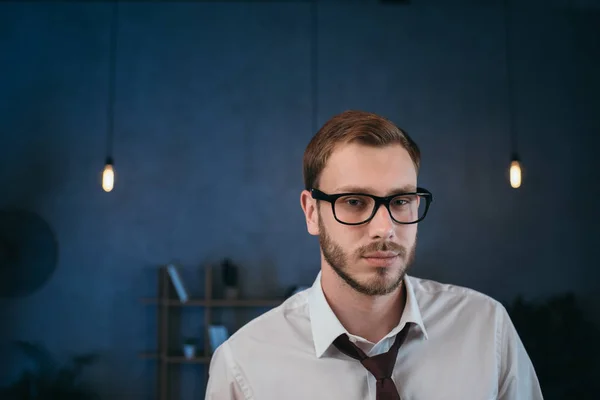 Бізнесмен в окулярах дивиться на камеру в офісі — стокове фото