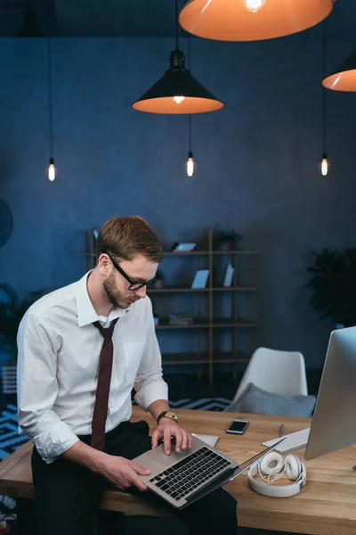 Jeune homme d'affaires travaillant sur ordinateur portable au bureau — Photo de stock