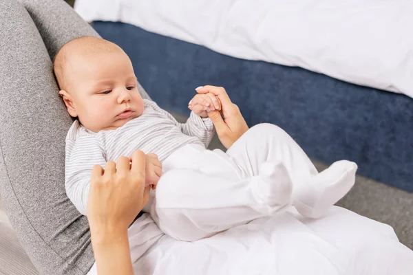 Madre sosteniendo manos de bebés - foto de stock