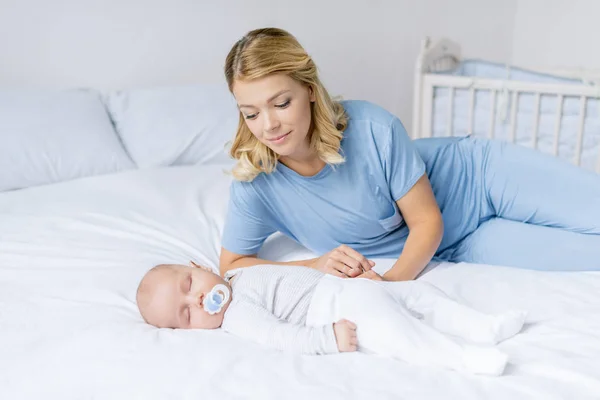 Mãe olhando para bebê dormindo — Fotografia de Stock