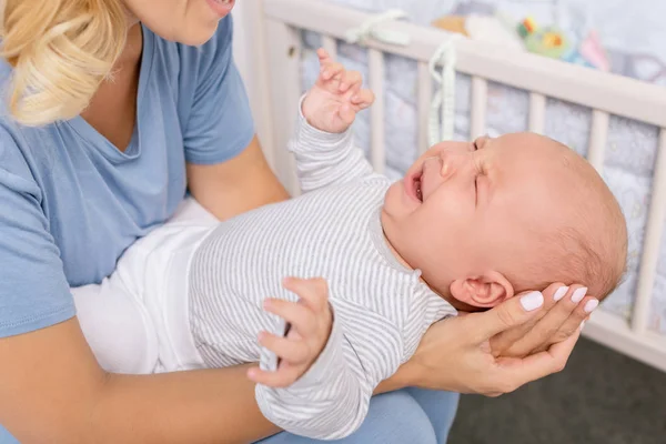 Mãe segurando bebê chorando — Fotografia de Stock