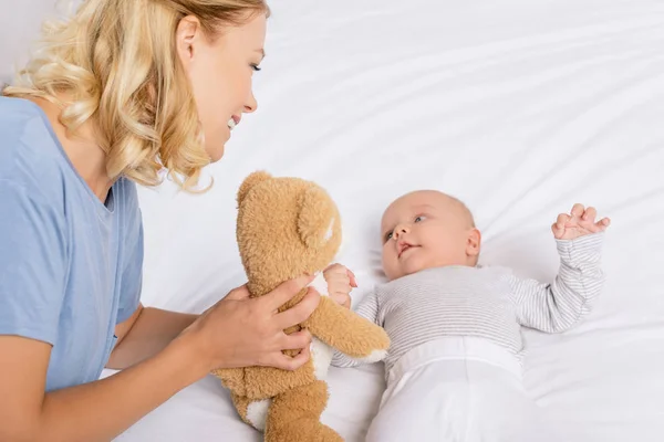 Mãe mostrando brinquedo para bebê — Fotografia de Stock