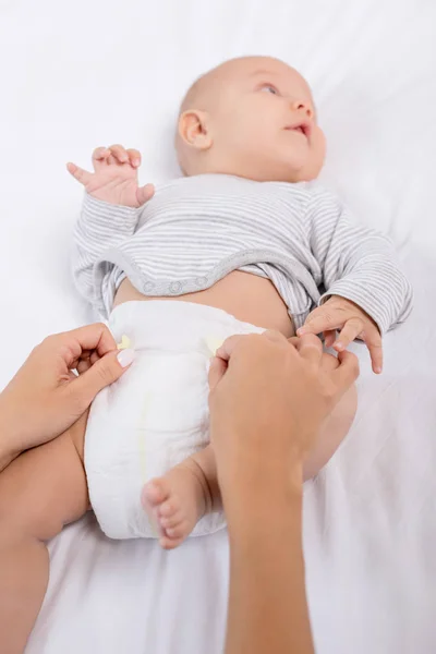 Mother changing babys diaper — Stock Photo