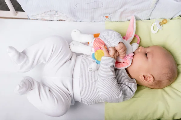 Baby mit Spielzeug im Kinderbett — Stockfoto