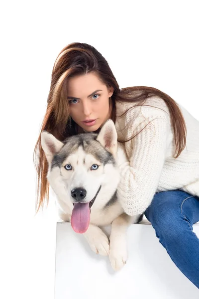 Hermosa chica abrazando perro husky, aislado en blanco - foto de stock