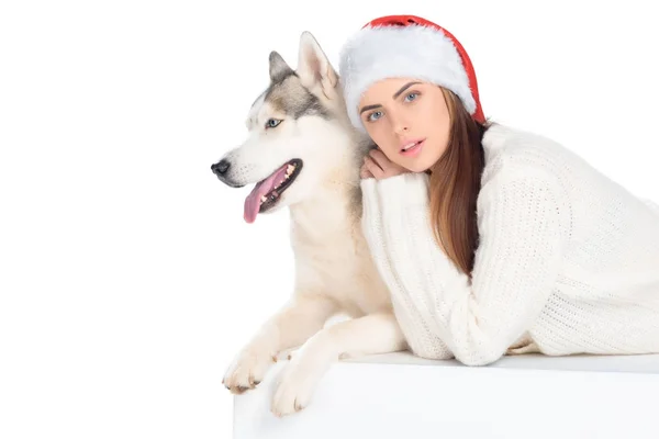 Хаскі собака і мила дівчина в капелюсі Санта, ізольовані на білому — стокове фото