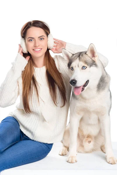 Husky dog and beautiful smiling woman in winter earmuffs, isolated on white — Stock Photo