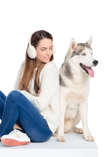 Husky dog and beautiful smiling girl in winter earmuffs, isolated on white — Stock Photo