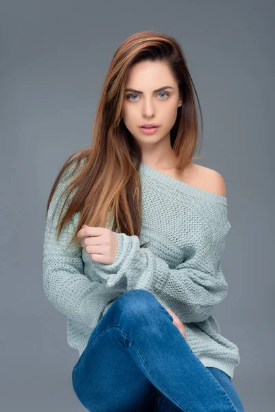 Beautiful stylish girl posing in sweater, isolated on grey — Stock Photo