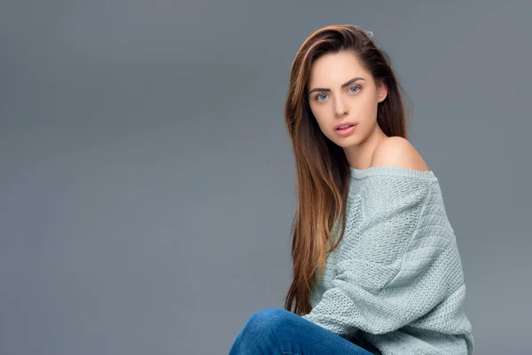 Menina elegante atraente em suéter olhando para a câmera, isolado em cinza — Fotografia de Stock