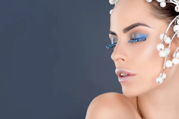 Hermosa mujer con los ojos cerrados con maquillaje de invierno y brillo, aislado en gris - foto de stock