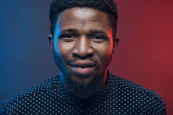 Portrait of handsome african american man on blue and red — Stock Photo