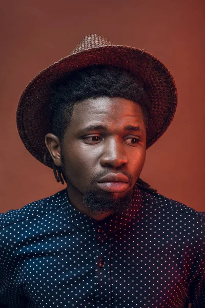 Стильный африканский американец в соломенной шляпе, изолированный от бордового — стоковое фото